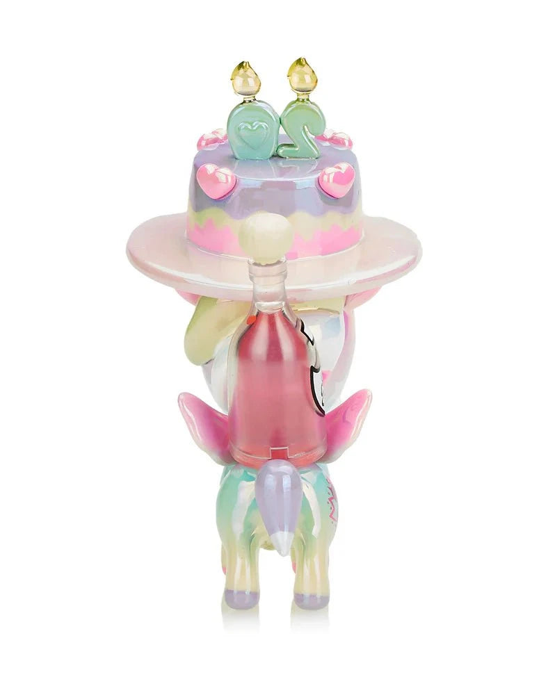 The Tokidoki 20 Candles Unicorno Special Edition figurine is a whimsical pastel unicorn holding a tiered cake with candles, celebrating the Twentieth Anniversary, featuring an enchanting design with a clear glass bottle.