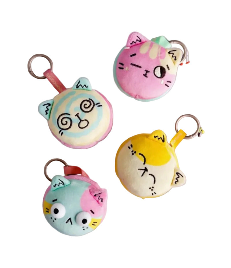 Four Meowcaron Plush Bag Charms by Kaleidos Creative, each with a unique facial expression, are arranged on a white background—perfect as adorable cat bag companions and cute plush keychains.