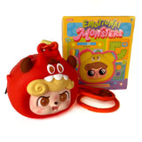 A round red Q.Kid Emotional Monster Headphone Bag by Jotoys, featuring a cartoon monster face with horns and yellow hair, sits before a colorful