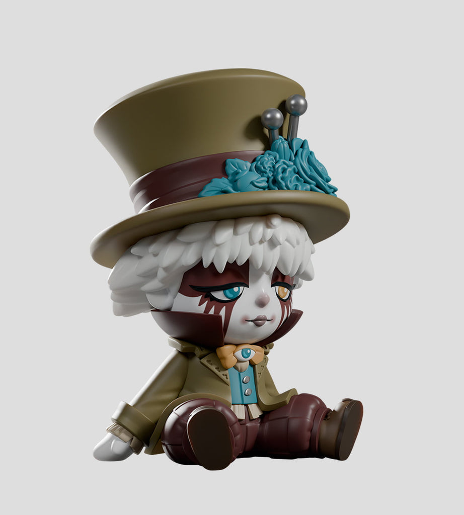 The A Mad Tea Party Blind Box by Kaleidos Creative features a circus clown-inspired vinyl figure with a large top hat, white hair, brown and white face paint, and a green coat—an ideal collectible for any blind box fan.