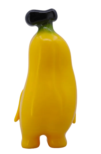 Banana Boo - Yellow by Rotofugi is a cute, yellow, cartoon-style banana figure with a black stem and two legs—perfect as a grocery-themed plush or collectible for fans of playful designs.