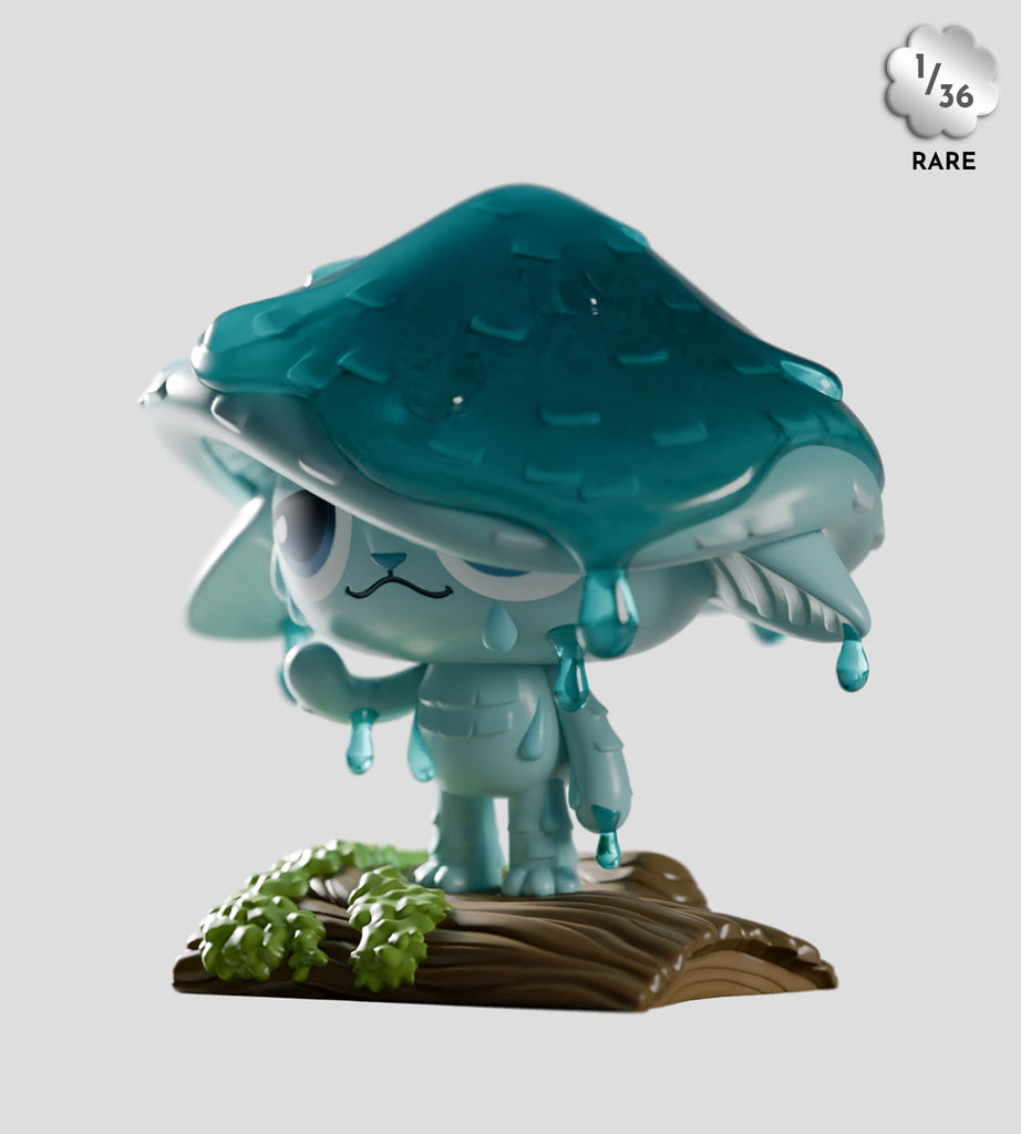 A small blue Capkins cat figurine with a large mushroom cap, water droplets, and a sad face stands on a wooden base. From Kaleidos Creative's rare (1/36) Capkins Series 1 Blind Box—Fungi Forest collection.