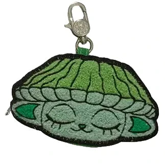 The Capkins Mystery Coin Bag by Kaleidos Creative is a collectible keychain with an embroidered green character featuring closed eyes and large ears, ideal for fans of blind box surprises or Capkins accessories.