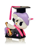 A Graduation Unicorno by Tokidoki toy proudly wearing a cap and gown, symbolizing achievement.