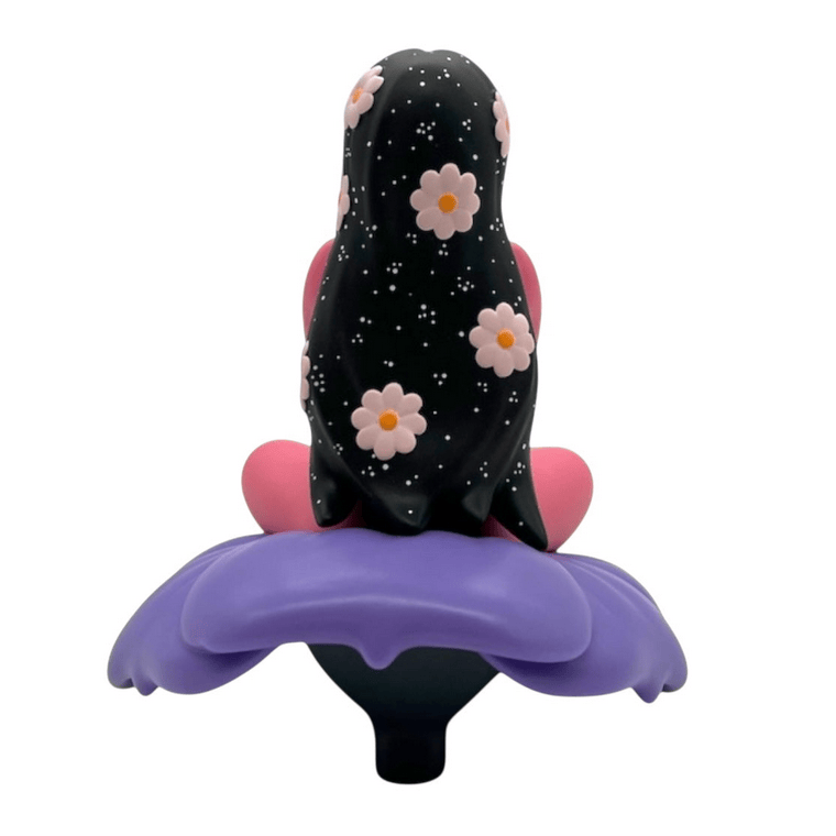 The Flower Girl collectible figure by UVD Toys (US) showcases a person with long, black hair adorned with flowers and stars, sitting cross-legged on a vibrant purple flower—an eye-catching gift for fans.