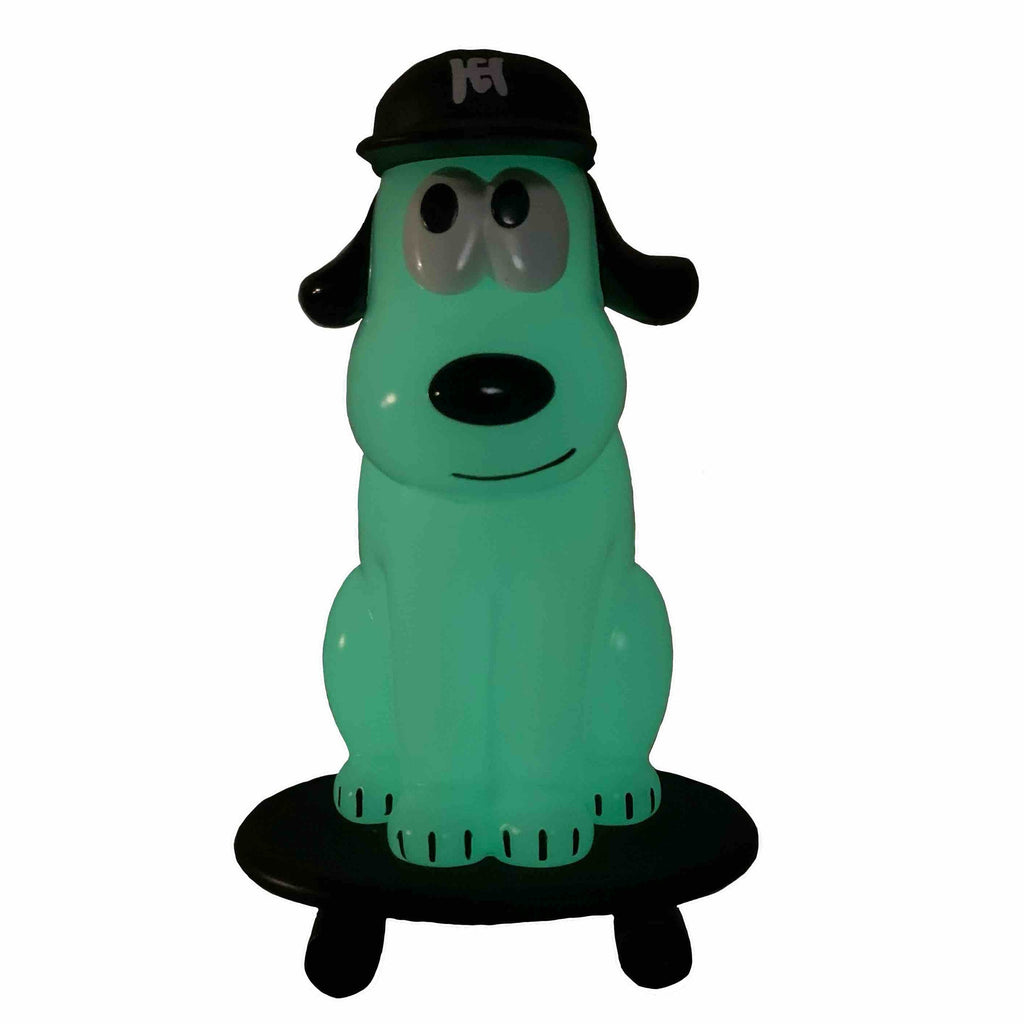 The How 2 Work One-Chu SK8 - Glow figure features a green cartoon dog in a black cap on a black base, perfect for fans of unique glow-in-the-dark collectibles.