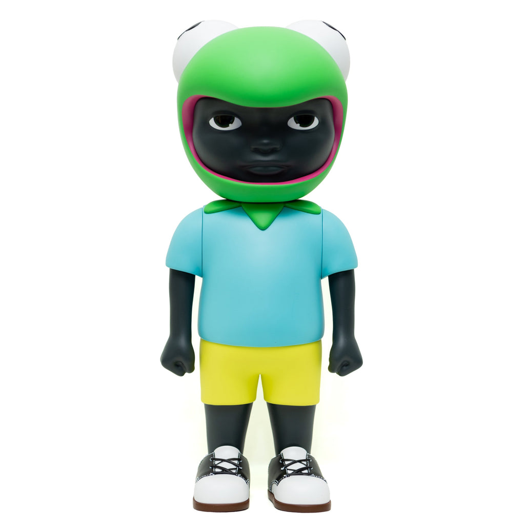 Introducing the limited edition Phibby — OG (Green) vinyl figurine of a black character wearing a frog hat, a light blue shirt, yellow shorts, and white shoes. Designed by Hebru Brand (US).
