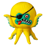 The VAG 40 β AHOY by Shelterbank, crafted by Medicom (JP), is a charming yellow toy octopus embodying the essence of Japanese vinyl toy design. It boasts a distinctive black eyepatch over one eye, a broad grin accentuated by sharp teeth, and a striking protruding red tongue. This piece makes for an enchanting addition to any gachapon figures collection!