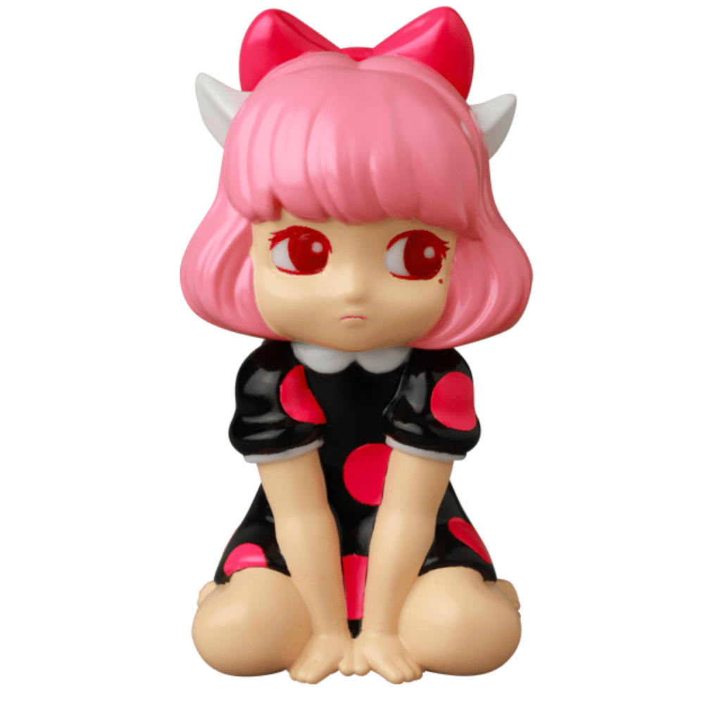 A Japanese vinyl toy, VAG 40 β Zombiecats Story Morimeiworks Nekomusume by Medicom (JP), showcases a character with pink hair, red eyes, and a pink bow. This figure wears a black dress adorned with pink dots and is posed sitting with knees bent, echoing the classic gachapon figures from Vinyl Artist Gacha collections.