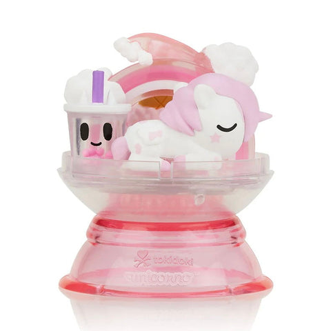 The Tokidoki Dreaming Unicorno - Strawberry Milk (Special Edition) features a pink and white Unicorno lying next to a smiling strawberry milk bubble tea cup on a clear pink base with a rainbow backdrop.