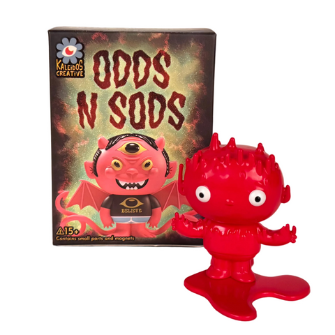 A red collectible figure stands before a Kaleidos Creative "Odds N Sods Blind Box," which displays artwork of a winged creature.