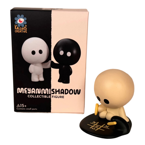 A rare figure from the Meyanmi Shadow Blind Box by Kaleidos Creative sits on a mat with yellow lines, its box featuring white and black character art—a must-have for blind box collectors.