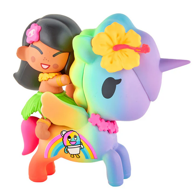 The tokidoki Hawaiian Ohana - Kailani & Anuenue (Special Edition) is a small figurine featuring a smiling girl in a hula skirt riding a pastel rainbow unicorn adorned with a flower and a cartoon rainbow chick.