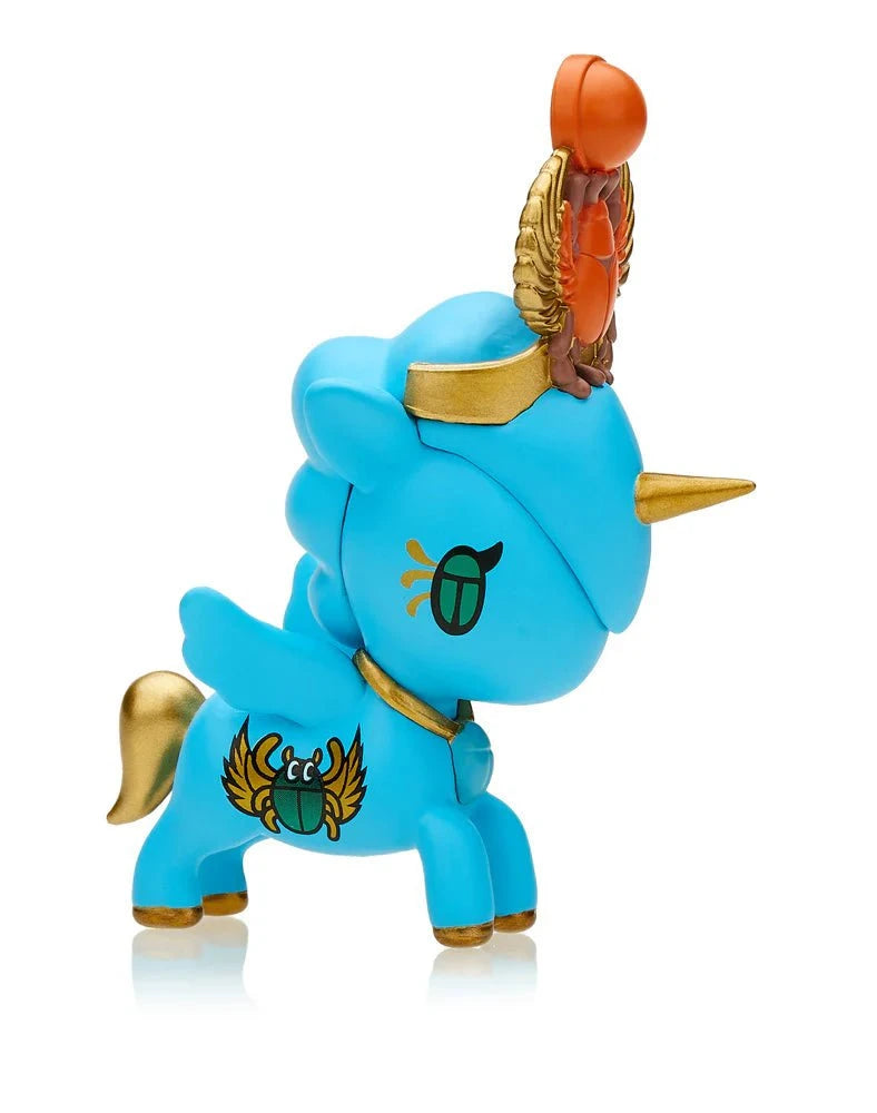 Introducing the Tokidoki Lucky Unicorno Blind Box: a mesmerizing blue unicorn figurine accented with gold, featuring a winged scarab and an Egyptian-inspired headdress complete with a red detail at the top. Add a touch of magic and good fortune to your collection with this enchanting piece from Tokidoki.