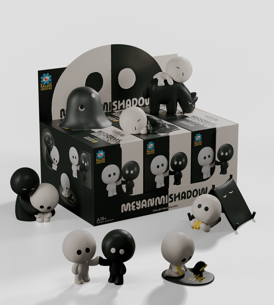 A display box of Kaleidos Creative's Meyanmi Shadow Blind Box features black and white collectible figures in playful poses—standing, hugging, or lying down—arranged in front of the blind box.