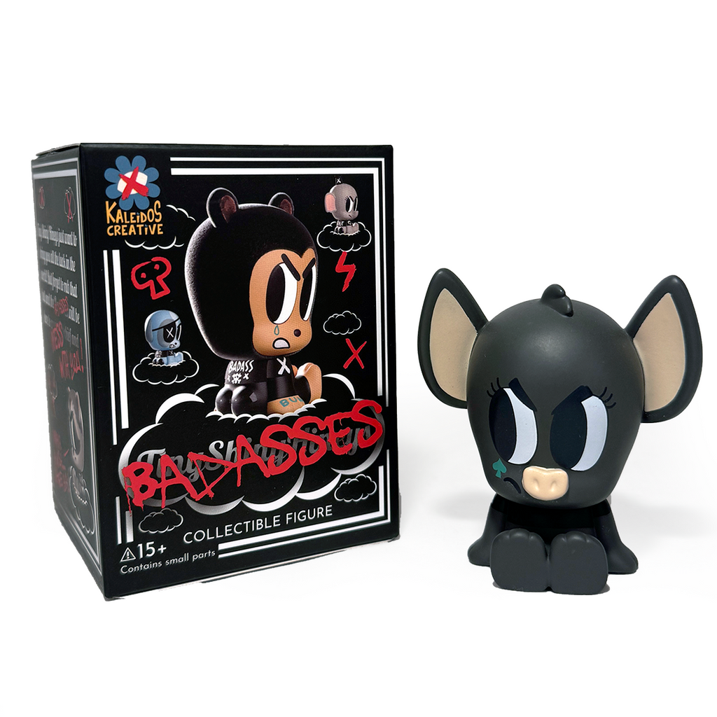 A vinyl collectible with big ears and bold eyes sits by its