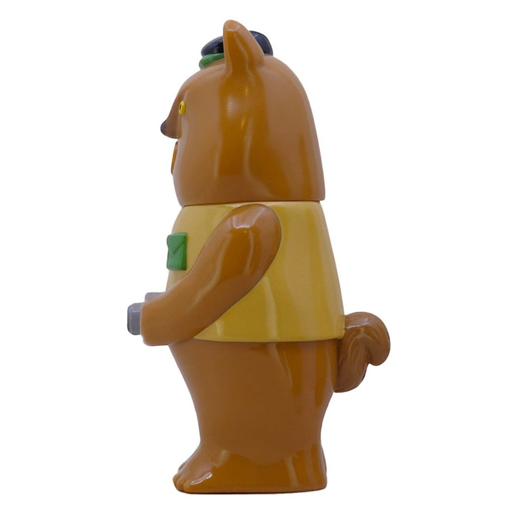 Side view of a limited edition Paradise Toy Mamechan- Milktea brown bear-shaped figure in a yellow vest holding a small green camera, isolated on white.