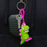 A fun tokidoki (IT) Characters series 1 Blind Bag Clip-On, this pink keychain features a green dinosaur.