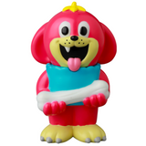 Uluru (VAG 43) by Medicom is a pink cartoon dog vinyl figure with a yellow crown, blue pillow, and white bone—smiling with its tongue out. This Japanese toy is inspired by Vinyl Artist Gacha gachapon figures.