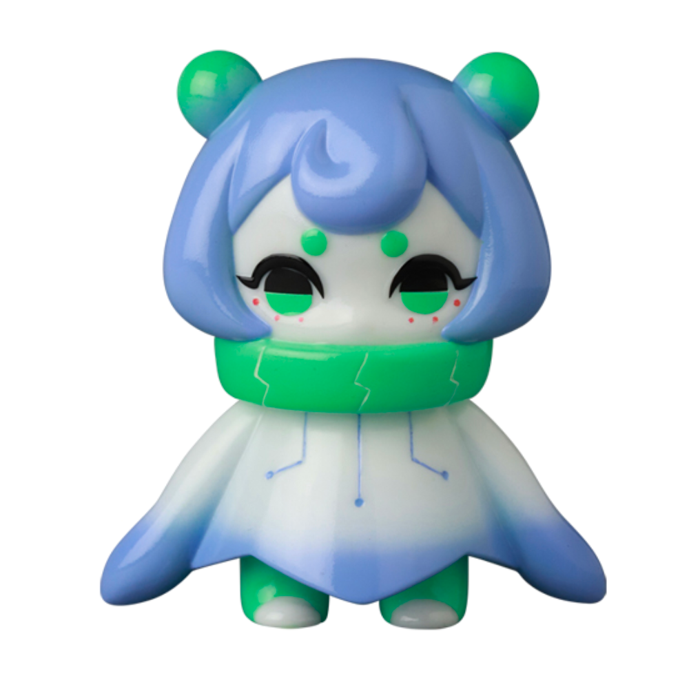 A small Japanese vinyl toy figure—VAG 10th Anniversary Denshikodako by Medicom (JP)—features a blue and white body, green accents, and a round head with two bear-like ears from the Vinyl Artist Gacha collection.