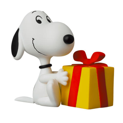 A Gift Snoopy figurine, the cartoon dog, seated next to a yellow gift box with a red ribbon, perfect for any occasion by Medicom (JP).