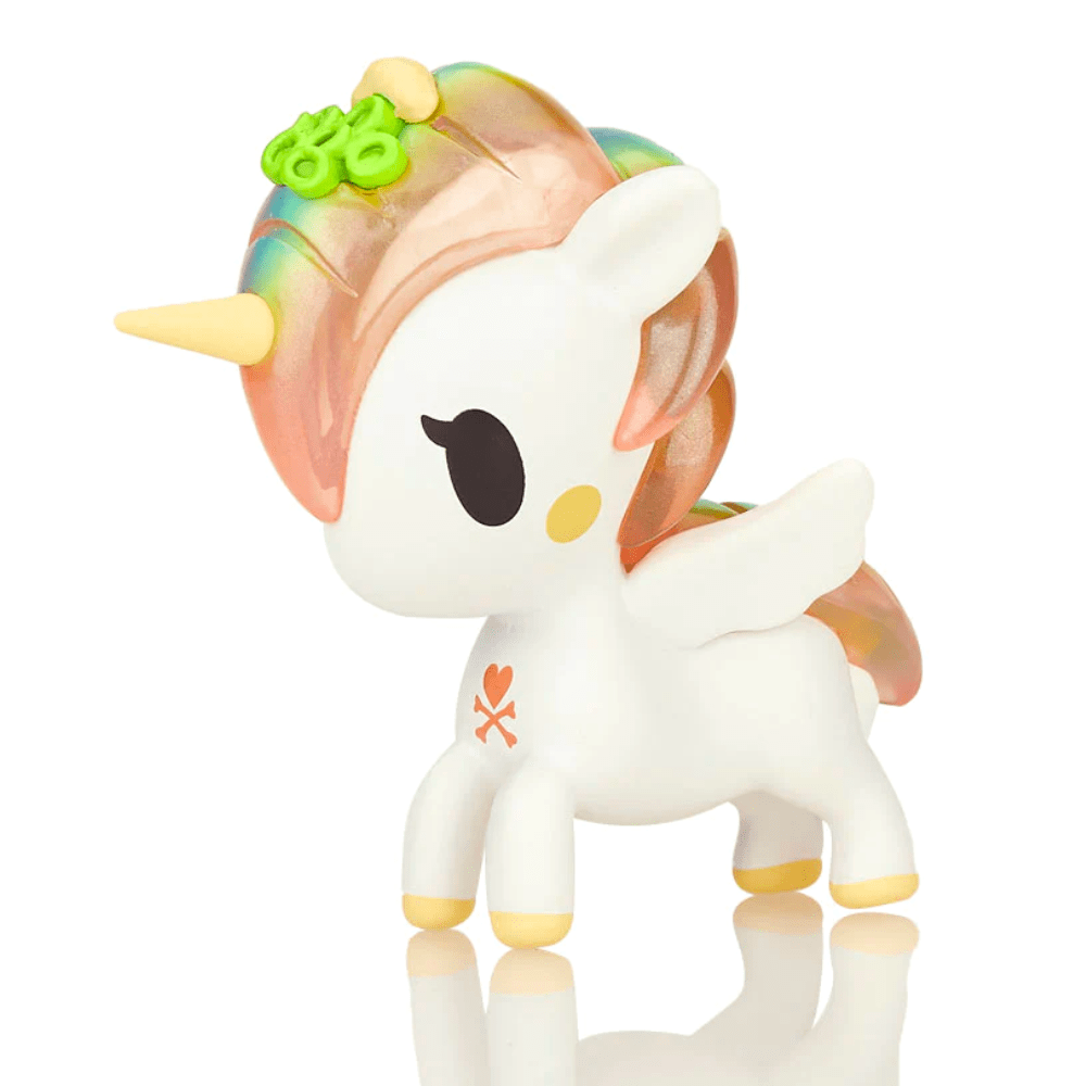 A small Tokidoki Sushi Unicorno - Aji (Limited Edition) toy unicorn is standing on a white surface, perhaps as a collectible or decoration inspired by tokidoki.