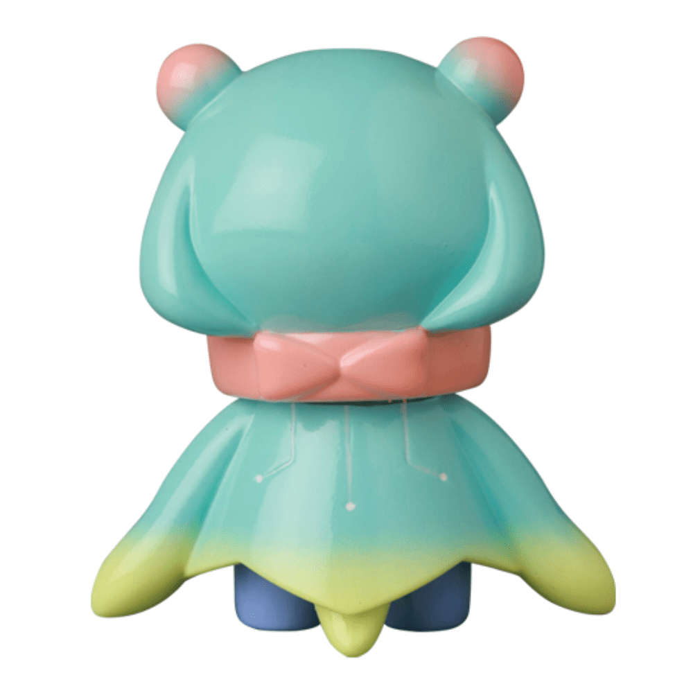 The VAG 10th Anniversary — Denshikodako by Medicom (JP) features a pastel bear-like figure with a pink bow and blue-green dress, shown from behind—ideal for Japanese vinyl toy gachapon collectors.