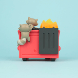 Two cartoonish gray cats playing on a red Dumpster Fire - Trash Panda Vinyl Figure toy with yellow flames from 100% Soft.