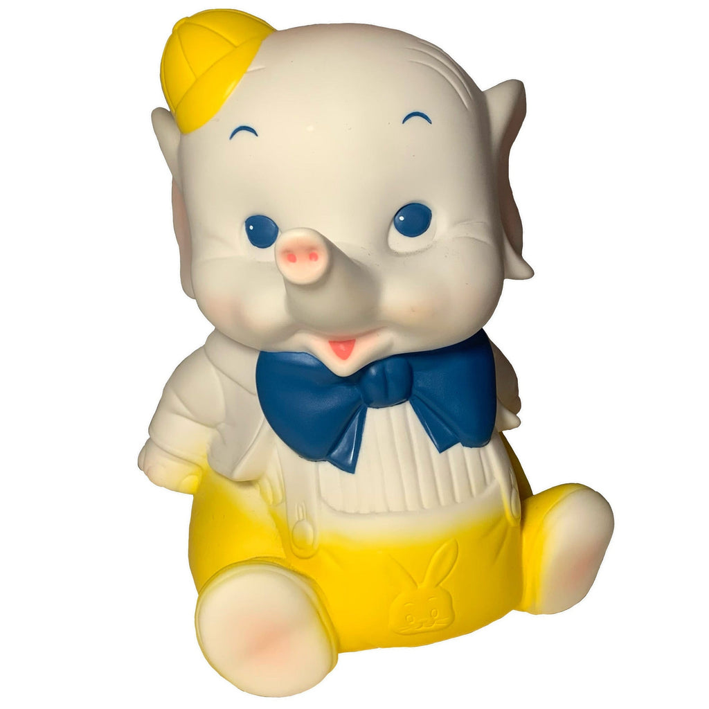The Yellow Bowtie Baby Elephant by Bitter Squeaks (US) is a stuffed animal with blue eyes, a yellow hat and pants, a white shirt, and a yellow bowtie, sitting upright against a white background.