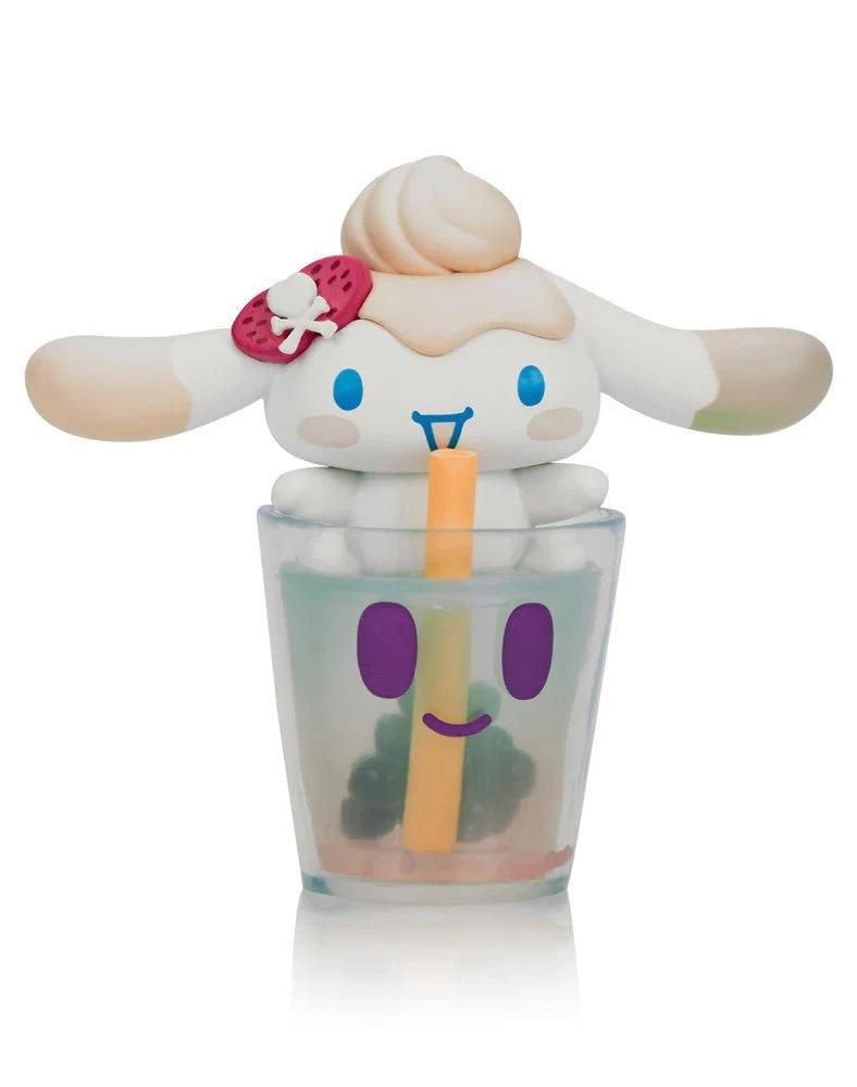 The Tokidoki x Cinnamoroll Sweet Treats Blind Box by Tokidoki features an adorable Cinnamoroll with a swirl head and strawberry bow sitting in a smiling bubble tea cup, holding a yellow straw.