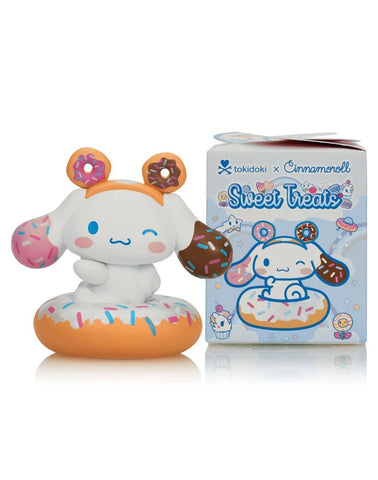 A Tokidoki x Cinnamoroll Sweet Treats Blind Box figurine features Cinnamoroll with donut-themed ears on a donut base, alongside the Tokidoki-branded box displaying matching character art.