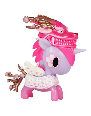The tokidoki Cherry Dragon Unicorno features pink and purple colors, a floral patterned cape, and a dragon mask with antler-like branches—perfect for celebrating sakura season.