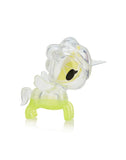 Observe the stunning unicorn-shaped figurine from Tokidoki's Toki Mochi Donut Unicorno Blind Bag collection, featuring a clear and green design with a yellow inner accent, a single horn, and large eye, elegantly posed on a reflective surface.