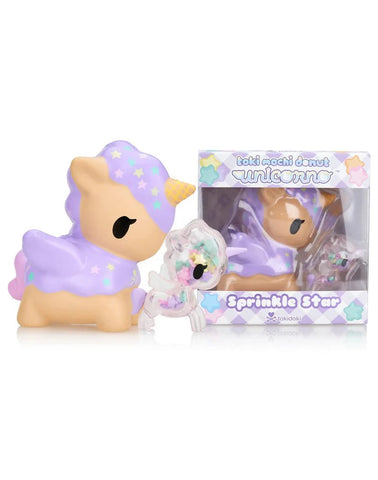 A pastel purple unicorn toy with a yellow horn and star accents is shown beside its box labeled "Toki Mochi Donut Unicorno Sprinkle Star Special Edition" from tokidoki.
