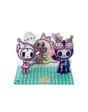 Celebrate Tokidoki’s 20th Anniversary with the Acrylic Standee Blind Box—each features three cute characters with cakes and party hats on a checkered base. Perfect for fans and collectors!.