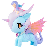 The tokidoki Mystical Dragon Unicorno - Fairy Dragon (Special Edition) features a pastel blue design with pink wings, a silver chain necklace, and a purple gem. Perched on its head is a small figure with purple hair and a pink dress. This special edition toy beautifully combines the enchanting details of a Dragon Fairy with tokidoki’s signature charm.