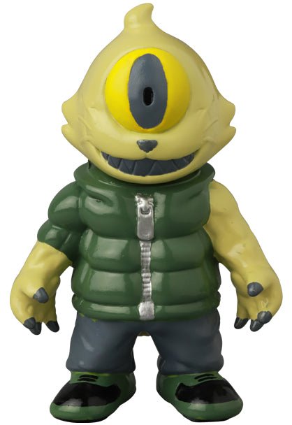 The VAG 41 — Gyaromioid by Medicom (JP) is a yellow, one-eyed vinyl monster figurine dressed in a green puffer vest, blue pants, and black shoes, standing and facing forward.