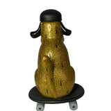 The How 2 Work One Chu Sk8- Gold figure features gold glitter and a black helmet, seated on a black skateboard, seen from behind.
