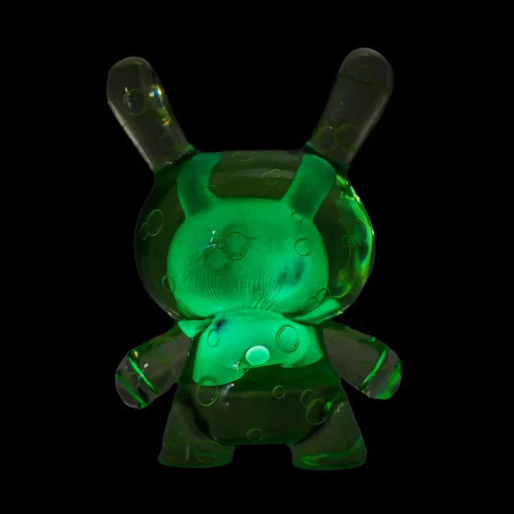 The Kidrobot Infected Specimen Dunny 8” GID Art Figure (LE 600) is a limited edition translucent green bunny-eared art toy with bubble-like patterns, presented by Kidrobot (US) against a black background.