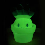 Hakusai-kun — Glow by Fewmany (JP), a glowing green plant character, smiles from its flowerpot against a dark background.