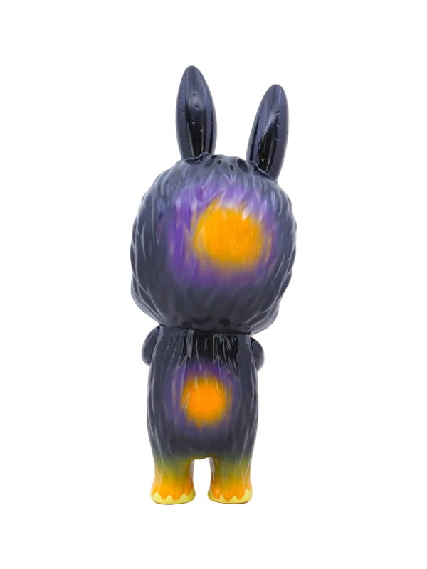 A collectible Labubu - Halloween toy figure by How2Work (HK), featuring a standing animal with long ears, dark fur, and yellow-purple gradient spots, shown from the back against a white background.