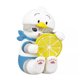 The Kitan Club (JP) Mofusand x Sanrio Series 2 Capsule-Set of 5 features a whimsical gray cat figurine in a duck costume holding a yellow lemon slice, perfectly capturing the playful Mofusand charm.