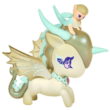 A charming winged fairy figure rests atop the head of the Pixie Dust Fairy Unicorno from tokidoki, which boasts golden wings, mint green horns, and a heart-shaped necklace. This whimsical Pixie Dust Fairy Unicorno Blind Box collectible toy features a unicorn with a unique bat-shaped mark near its eye and a pink heart motif on its body.