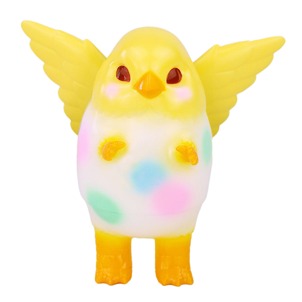 Pigora — Easter Egg by Konatsuya (JP) is a yellow-winged, bird-like toy inspired by the kaiju Pigora, featuring pastel spots on its white body. The figure stands upright against a white background.