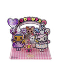 Celebrate Tokidoki’s 20th Anniversary with this Acrylic Standee Blind Box featuring cute characters in donut-themed outfits under a “DONUTS” sign—an adorable collectible surprise for any Tokidoki fan!.