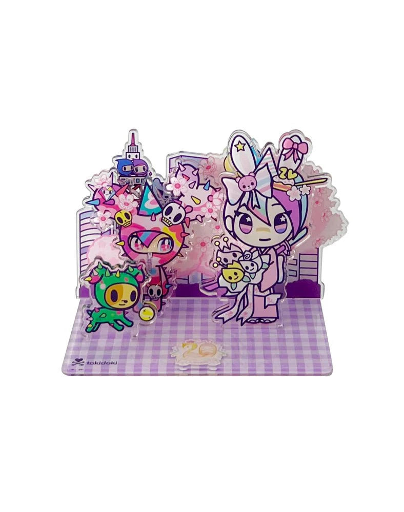 Celebrate Tokidoki's 20th Anniversary with the Tokidoki 20th Anniversary Acrylic Standee Blind Box, featuring colorful cartoon characters in animal costumes and cherry blossoms on a purple checkered base.