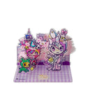 Celebrate Tokidoki's 20th Anniversary with the Tokidoki 20th Anniversary Acrylic Standee Blind Box, featuring colorful cartoon characters in animal costumes and cherry blossoms on a purple checkered base.