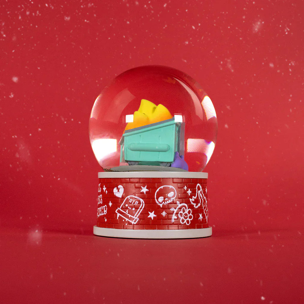 The 100% Soft Dumpster Fire Snow Globe features a mini green dumpster with colorful trash on a red base and falling snow—perfect quirky desk decor for the season.