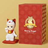 A small figurine of a Sonny Angel Lucky Cat Collectors Trophy sitting next to a box, perfect for a collection.