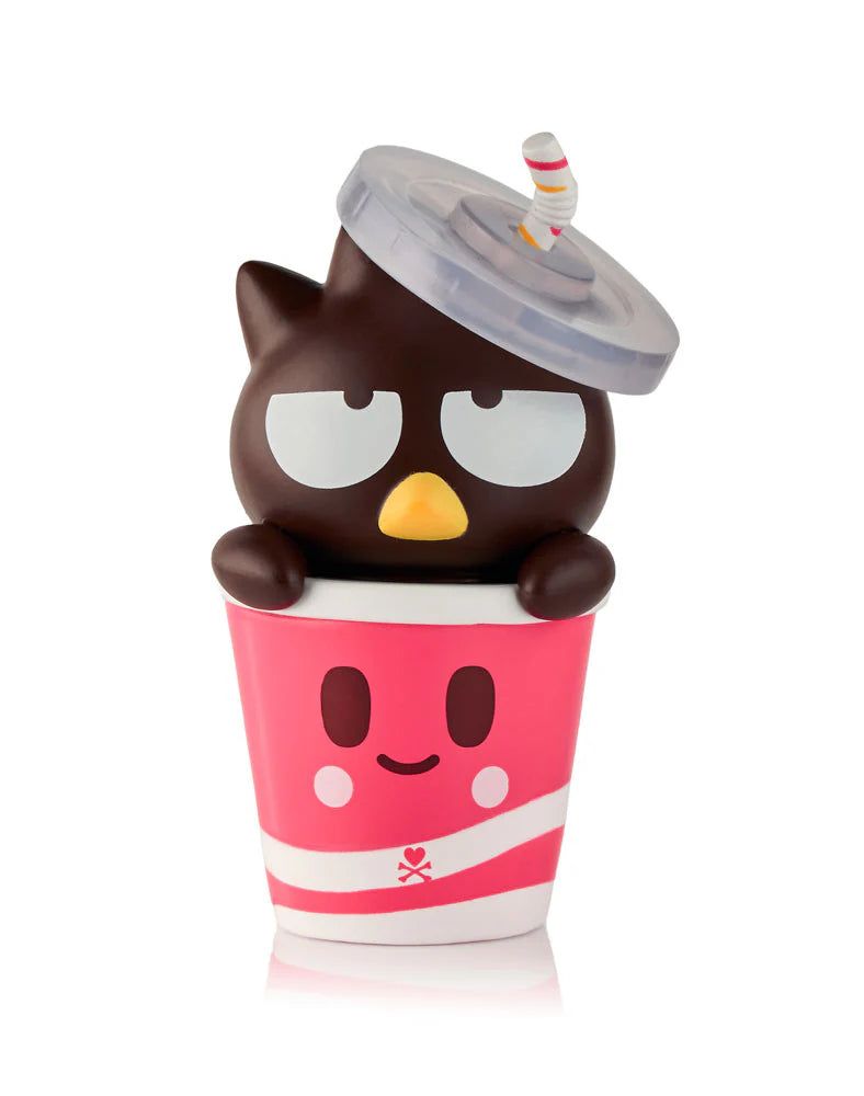 From the tokidoki (IT) Tokidoki x Hello Kitty & Friends Fast Food Blind Box, a cute black cartoon bird with droopy eyes sits in a pink smiley-face cup with a straw—perfect for any collectible figures display.